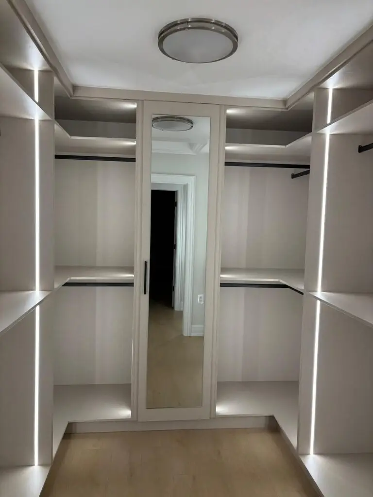Custom master closet design with LED lighting and mirror doors