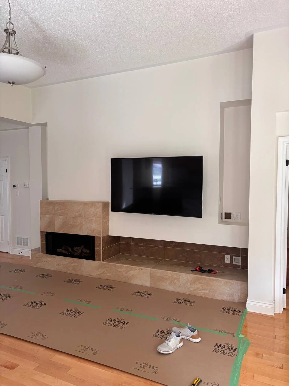Original Ballantrae living room wall with an off-centre gas fireplace, tiled hearth and wall-mounted television